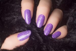 Elegant purple glitter nails with pretty purple designs, including acrylic purple nail art.