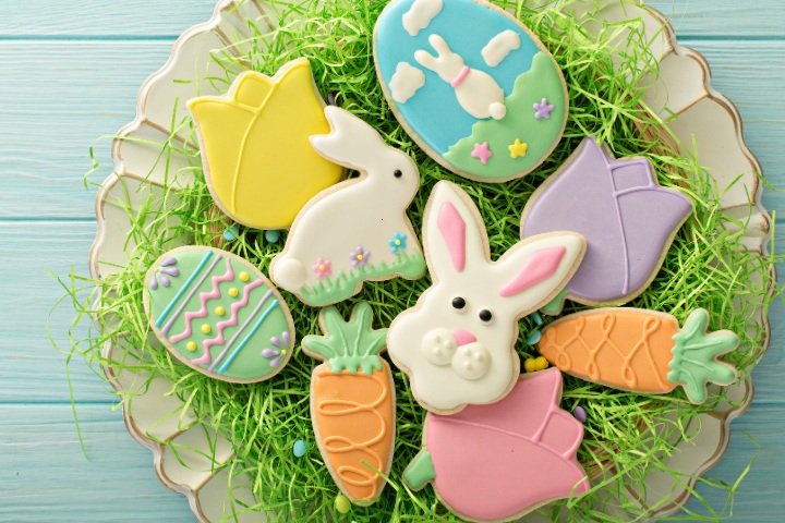 A vibrant array of Easter cookies decorated with icing, including bunny cookies, Easter egg cookies, and Easter basket cookies.