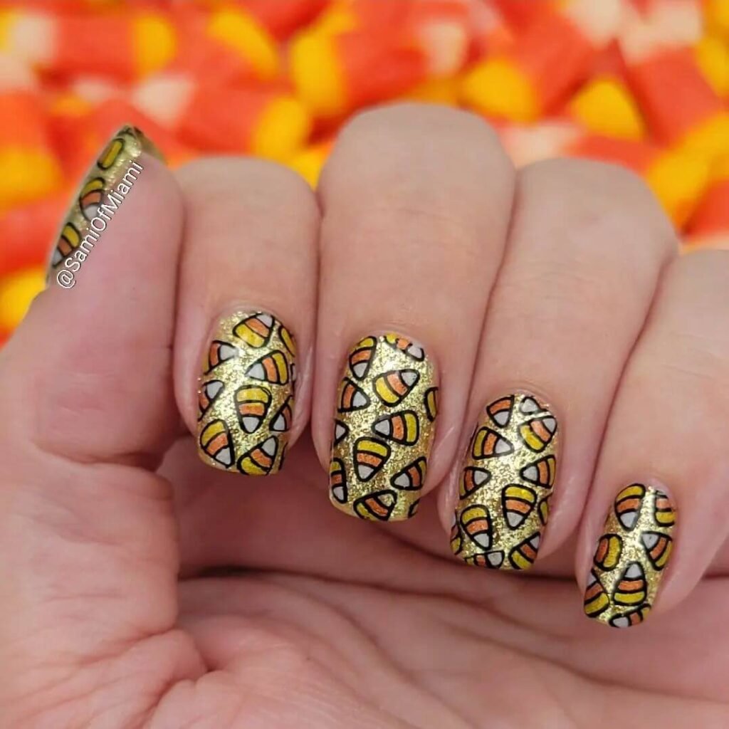 Close-up of candy corn nails with vibrant yellow, orange, and white stripes, perfect for Halloween.