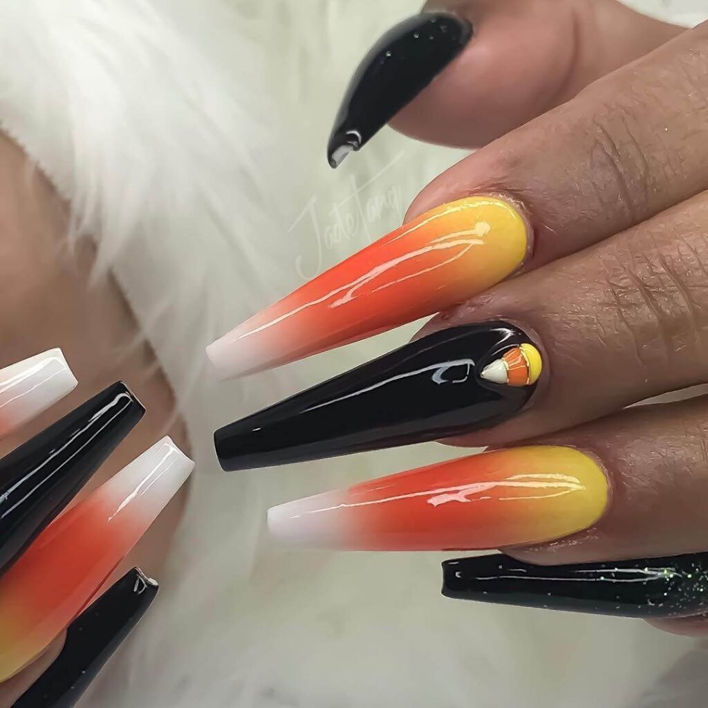 Close-up of candy corn nails with vibrant yellow, orange, and white stripes, perfect for Halloween.