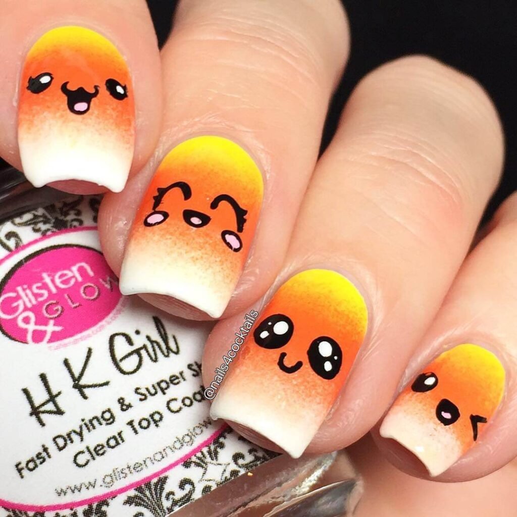 Close-up of candy corn nails with vibrant yellow, orange, and white stripes, perfect for Halloween.