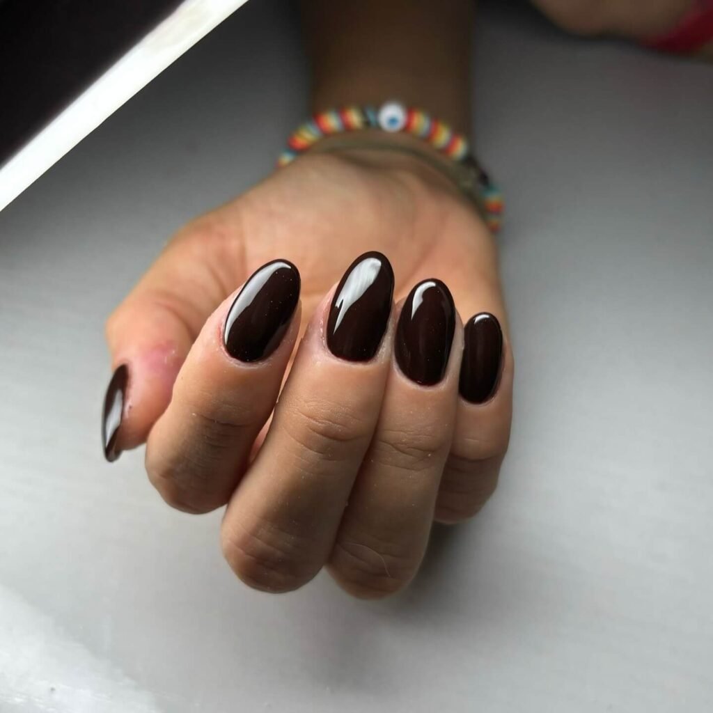 beautifully designed dark nails featuring black and burgundy fall nail designs with a glossy finish.