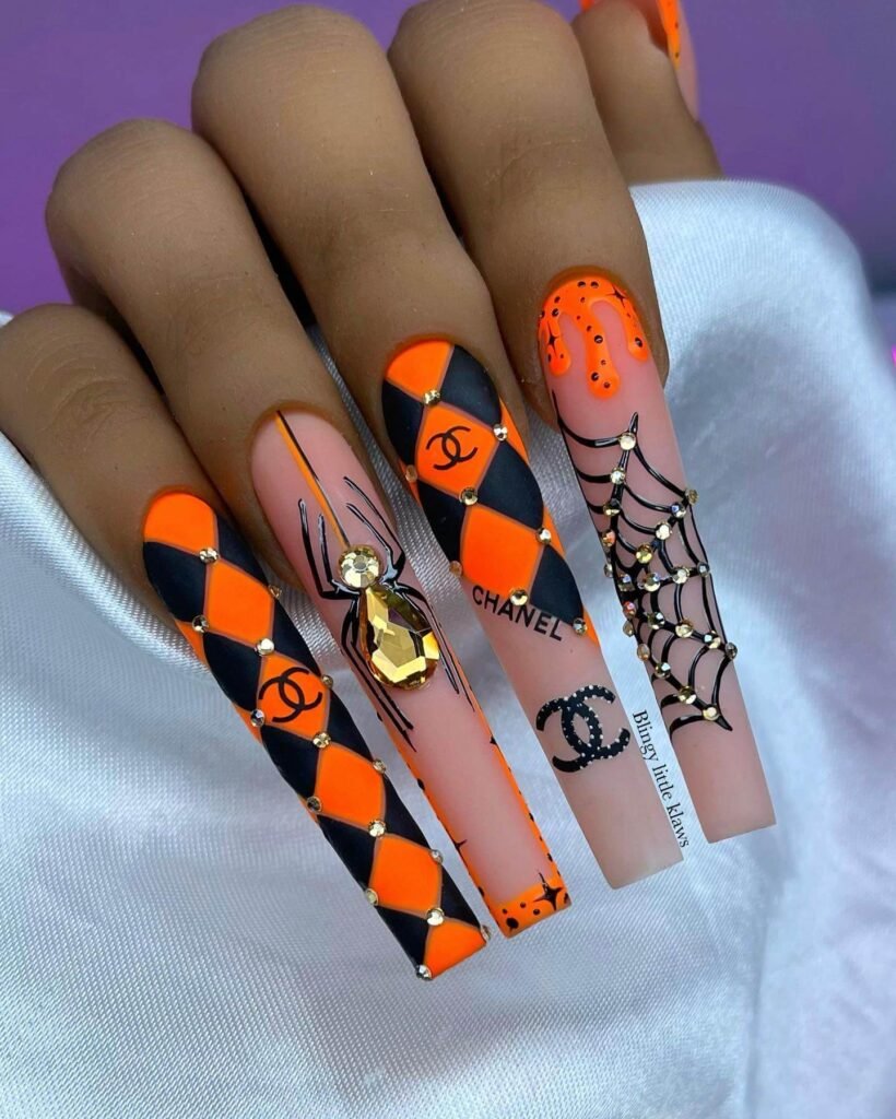 A set of spooky Halloween acrylic nails with designs like bats, ghosts, and pumpkins, ideal for October.