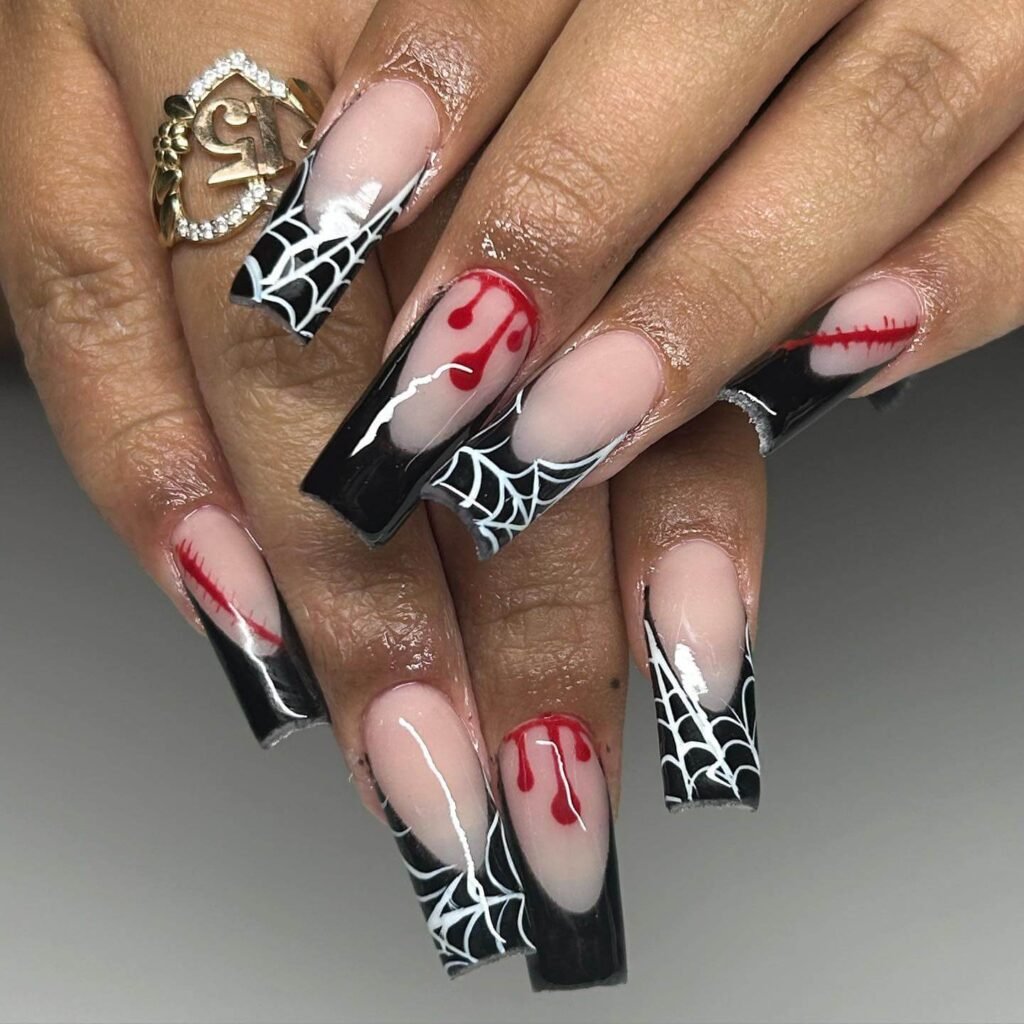 A set of spooky Halloween acrylic nails with designs like bats, ghosts, and pumpkins, ideal for October.