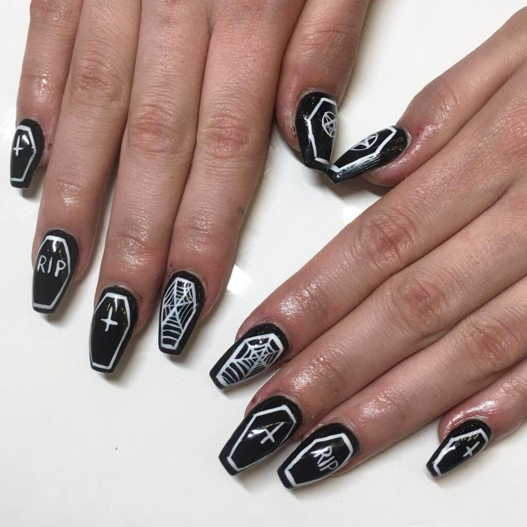 A set of spooky Halloween acrylic nails with designs like bats, ghosts, and pumpkins, ideal for October.